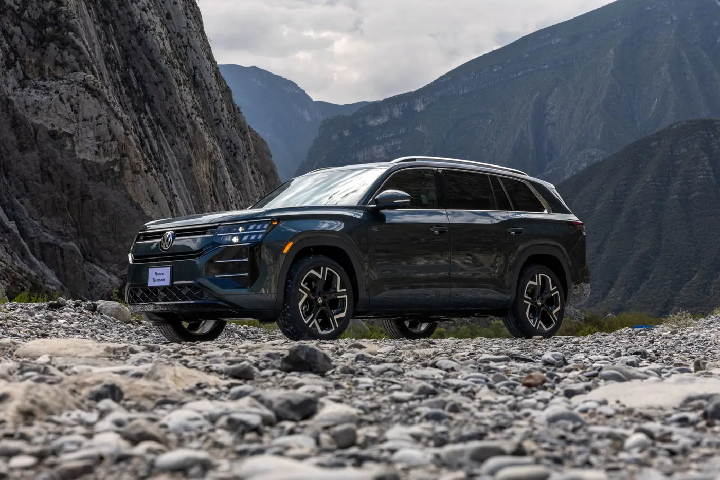 Volkswagen Teramont 2027 verde oscuro de tres cuartos frente a una montaña